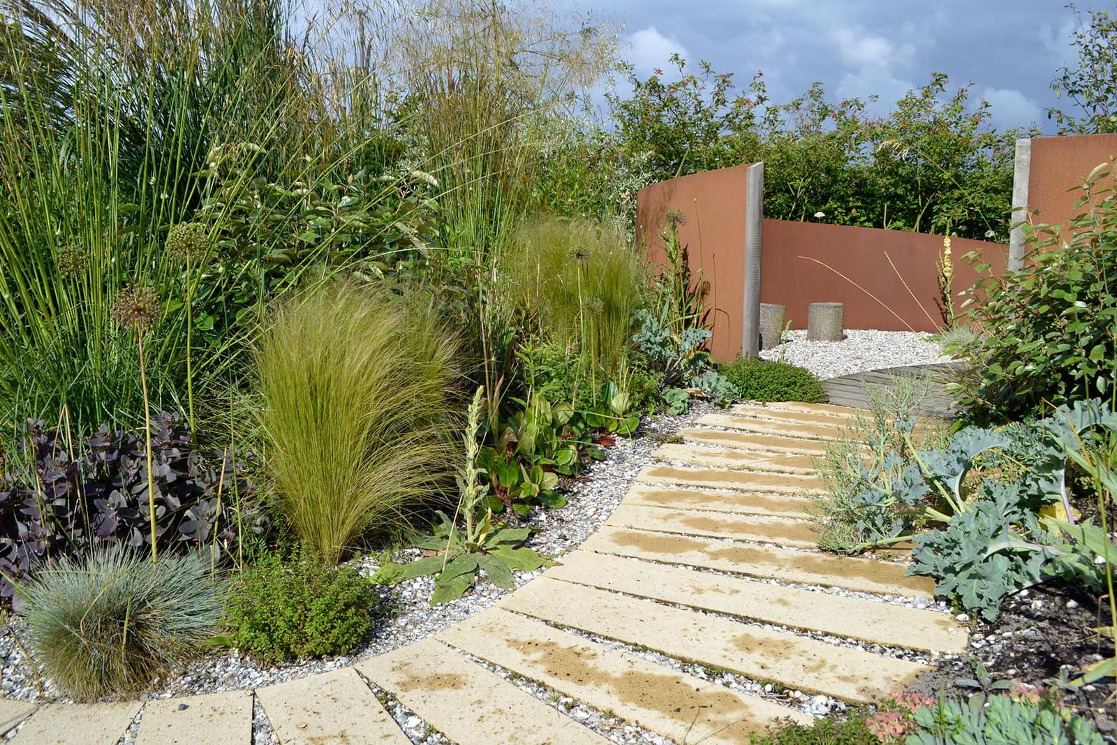 Duintuin met grassen en vaste planten tussen schelpengrind