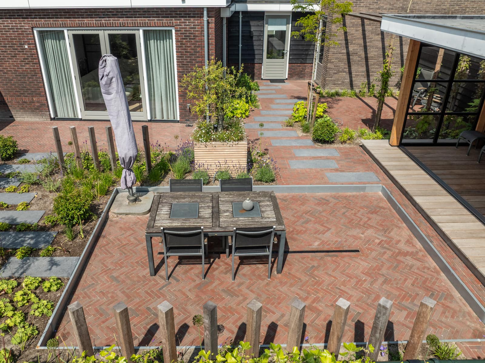 Reijersgroet: ruim terras van gebakken klinkers met eettafel